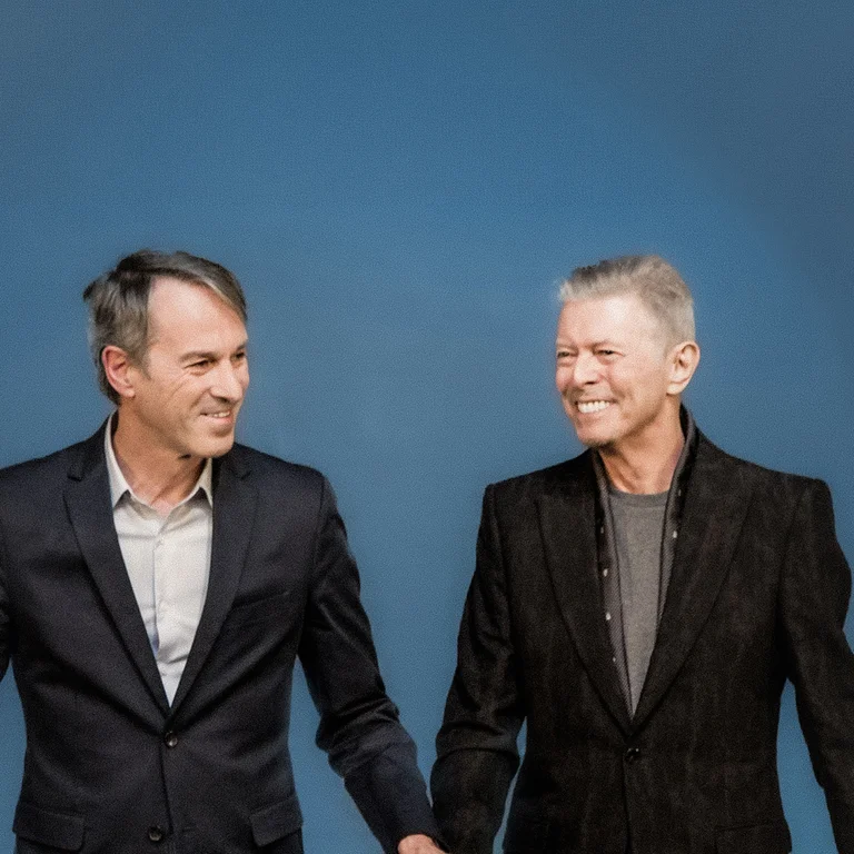 Ivo Van Hove mit David Bowie vor blauem Hintergrund