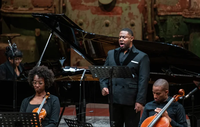 Key'mon Murrah tritt leidenschaftlich auf der Bühne mit Klavier- und Streichmusikern auf.