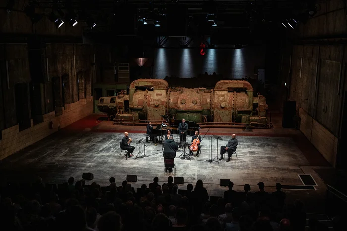 Alexander Laing, Yshani Perinpanayagam, Sarah Martin, Tyshawn Sorey, Key'mon Murrah, Khari Joyner, Joshua Stewart tritt auf einer industriellen Bühne vor Publikum auf.