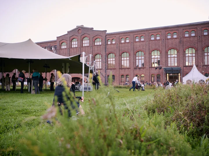 Die Maschinenhalle Zweckel in Gladbeck mit einer großen Backsteinfassade und begrüntem Außenbereich, im Abendlicht aufgenommen.