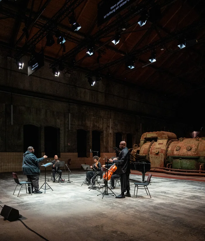 Tyshawn Sorey, Alexander Laing, Sarah Martin, Khari Joyner, Joshua Stewart auf einer industriellen Bühne.