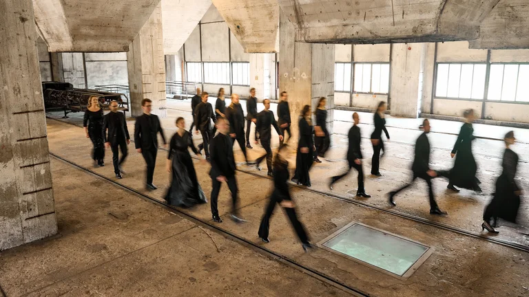 Die Sängerinnen und Sänger von Chorwerk Ruhr laufen durch die Trichtereben der Mischanlage auf der Zeche Zollverein.